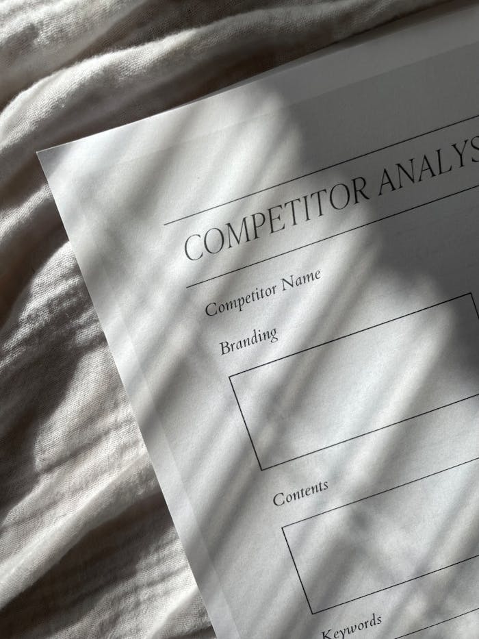 A competitor analysis sheet with stylish shadows on a textured fabric background, conveying a professional tone.